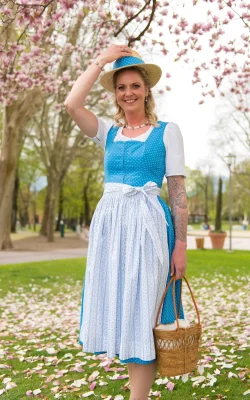 Frau in Hellblauer Tracht mit Hut und Korb